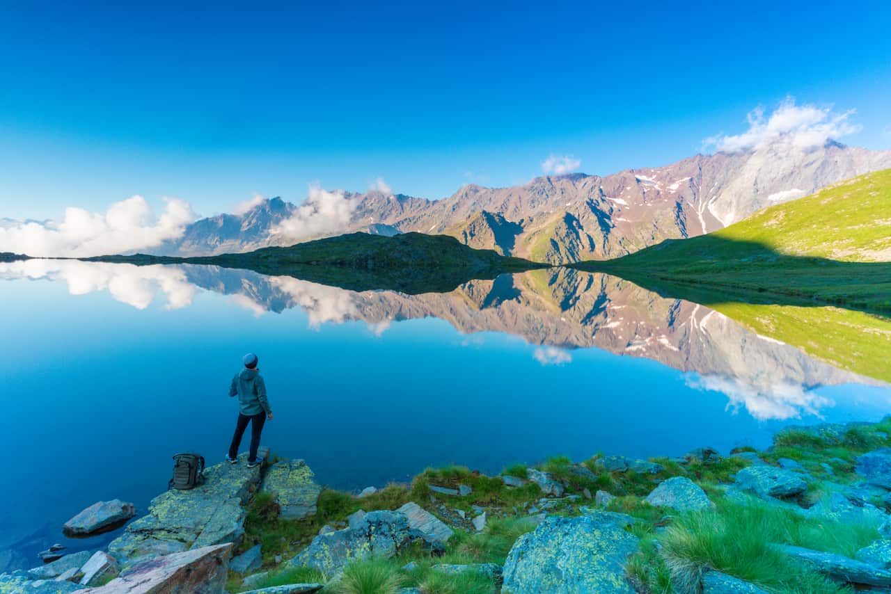 Hiker admiring Lago Nero, Gavia Pass, Lombardy, Italy
