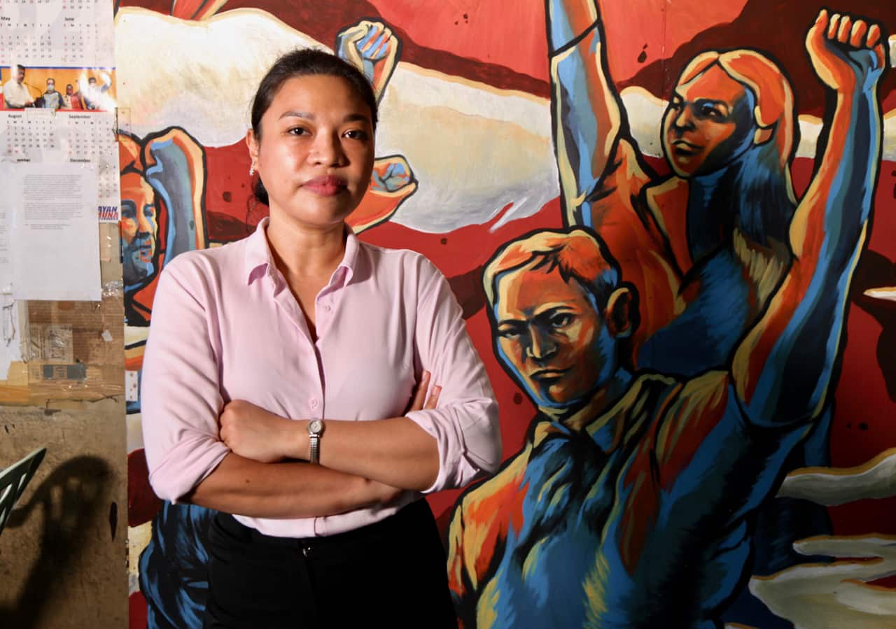 Kristina Conti stands in front of a mural 