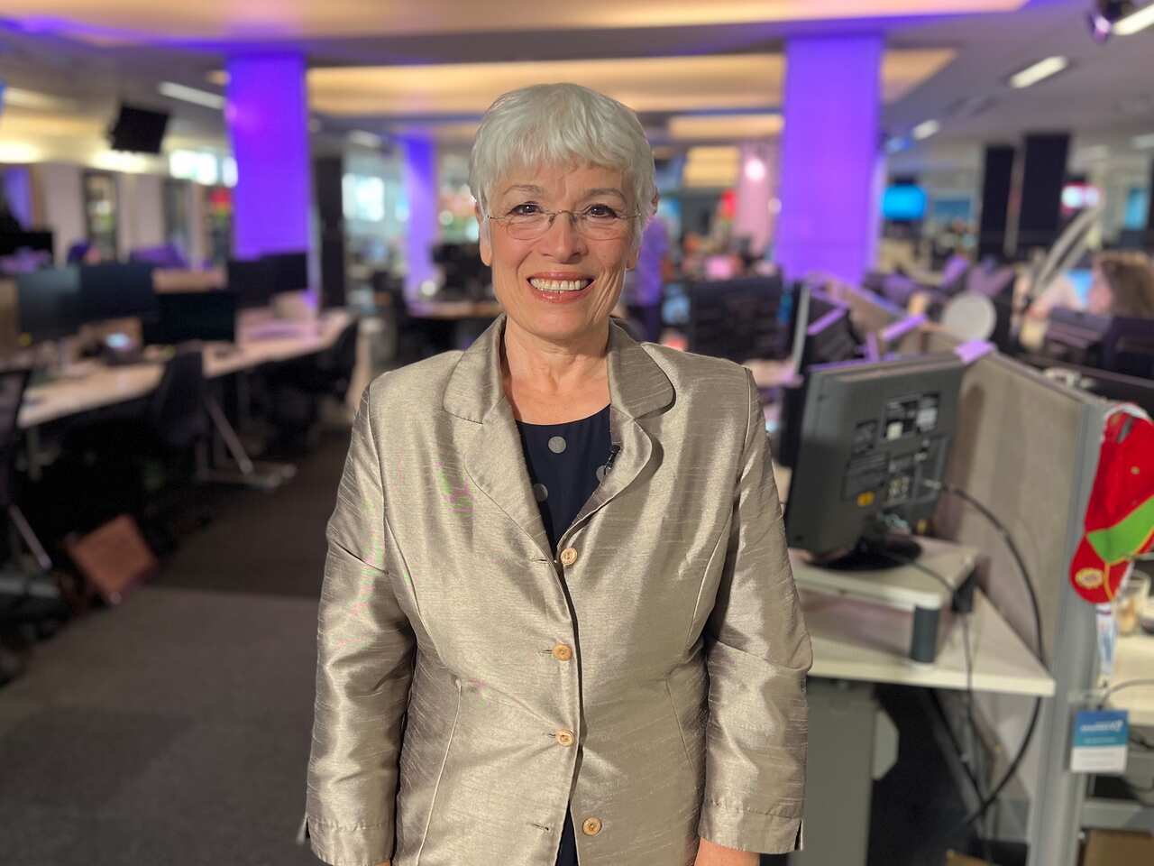 A woman in a silver suit standing inside 