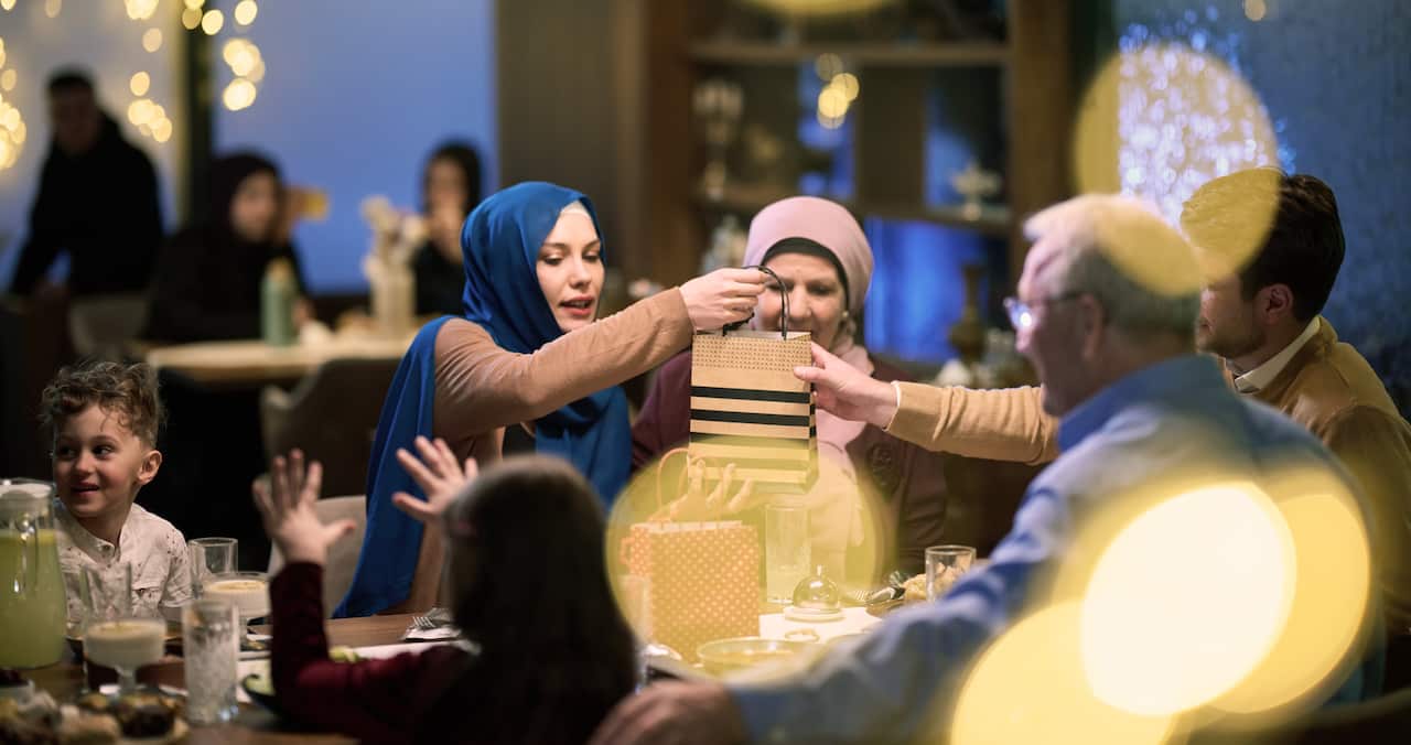 Grandparents arrive at their children's and grandchildren's gathering for iftar in a restaurant during the holy month of Ramadan, bearing gifts and sharing cherished moments of love, unity, and cultural exchange, as they eagerly await their meal together