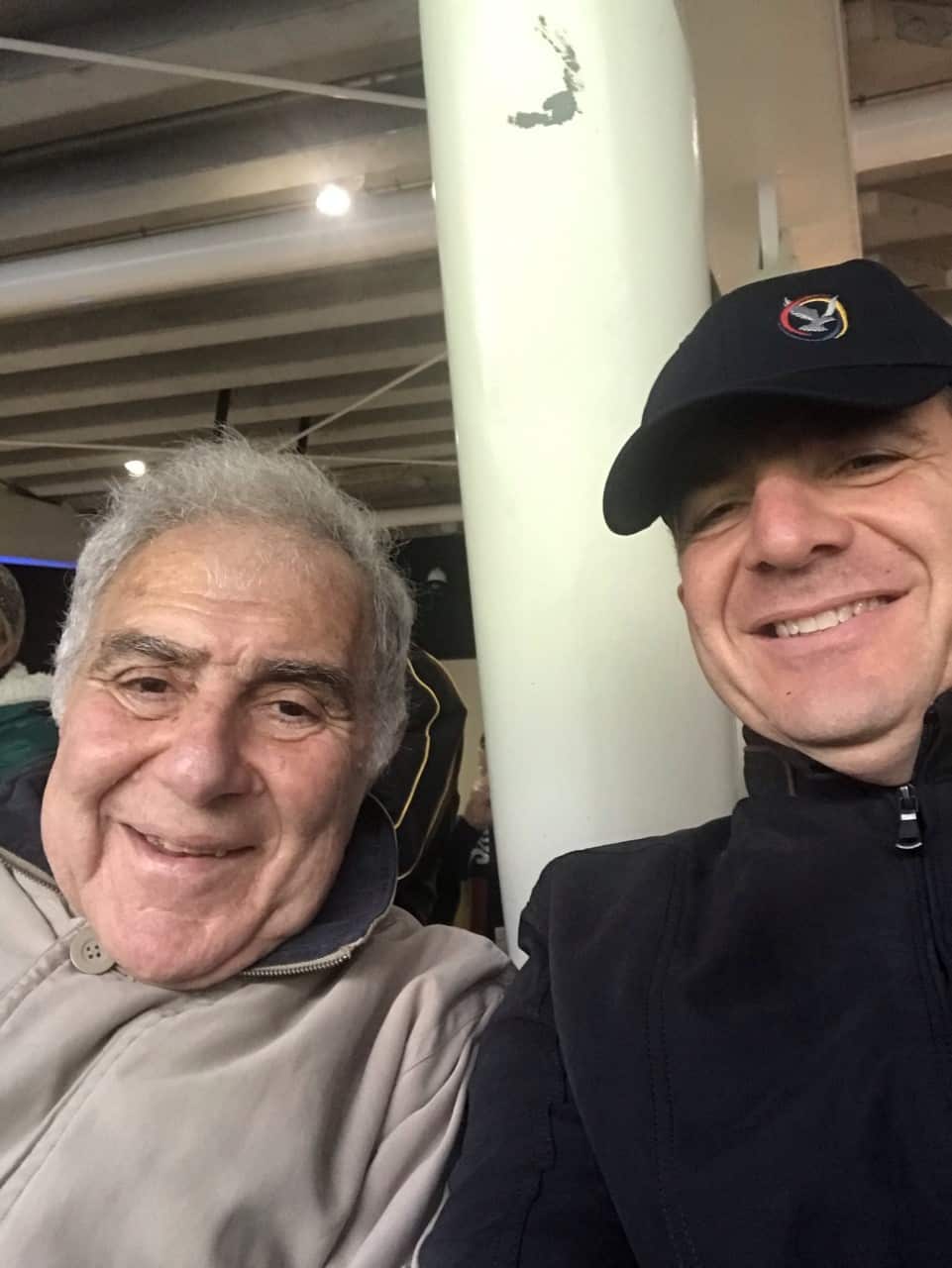 A selfie of Peter with his father while in the crowd at an AFL game.