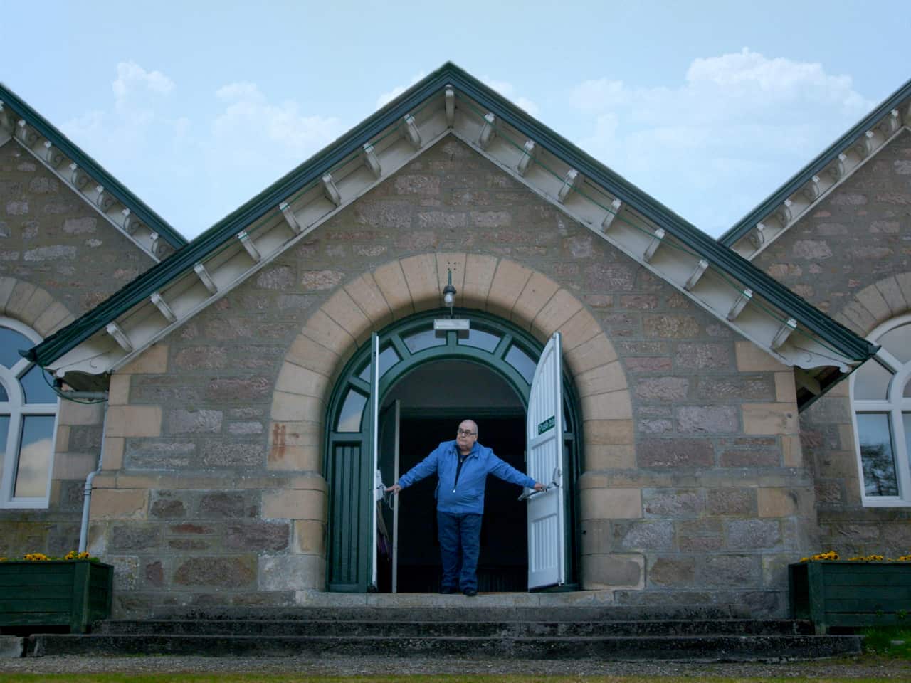 A man opening the doors of a church.