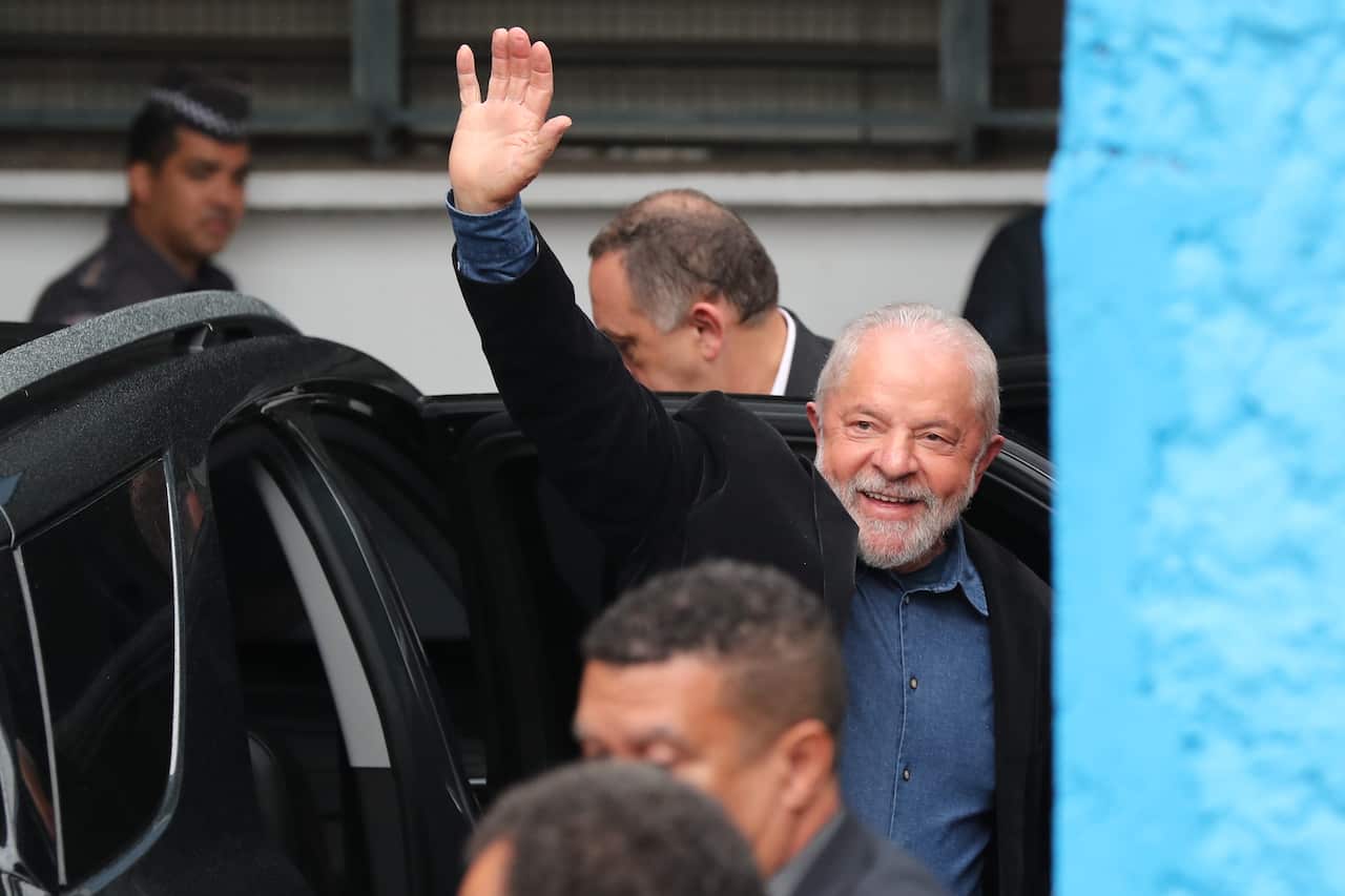 A man waving next to a car