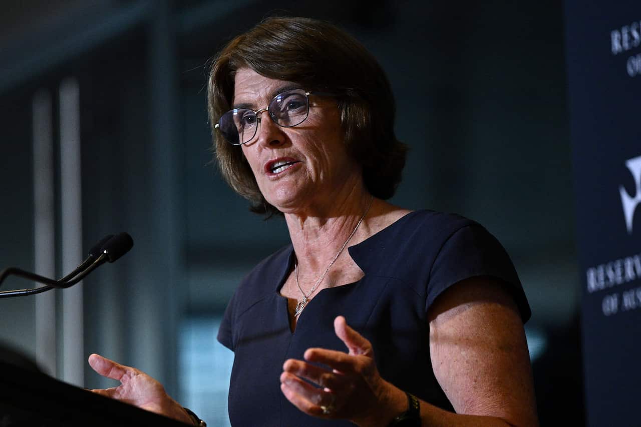 Michelle Bullock, standing at a podium and speaking into a microphone.