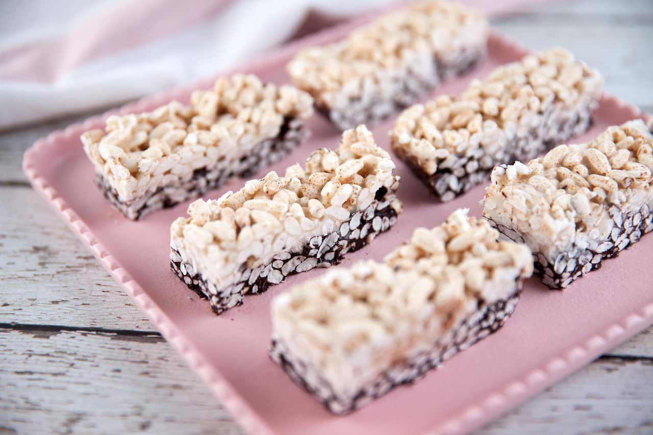 Six pieces of double decker slice: chocolate on the bottom, white chocolate and puffed rice on the top.