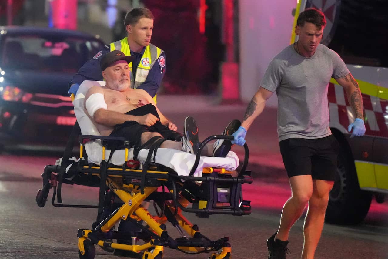 A shirtless man being wheeled in a stretcher