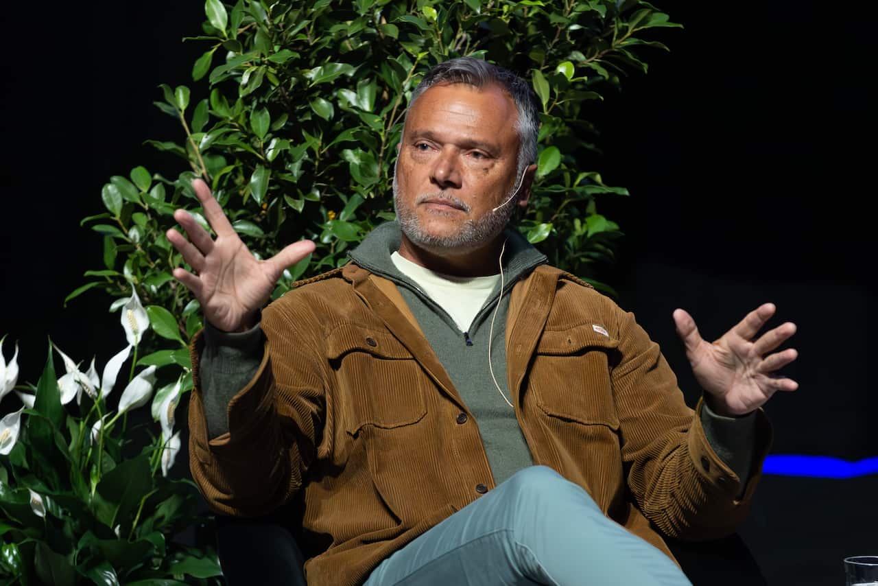 Stan Grant sitting on stage talking to an audience.