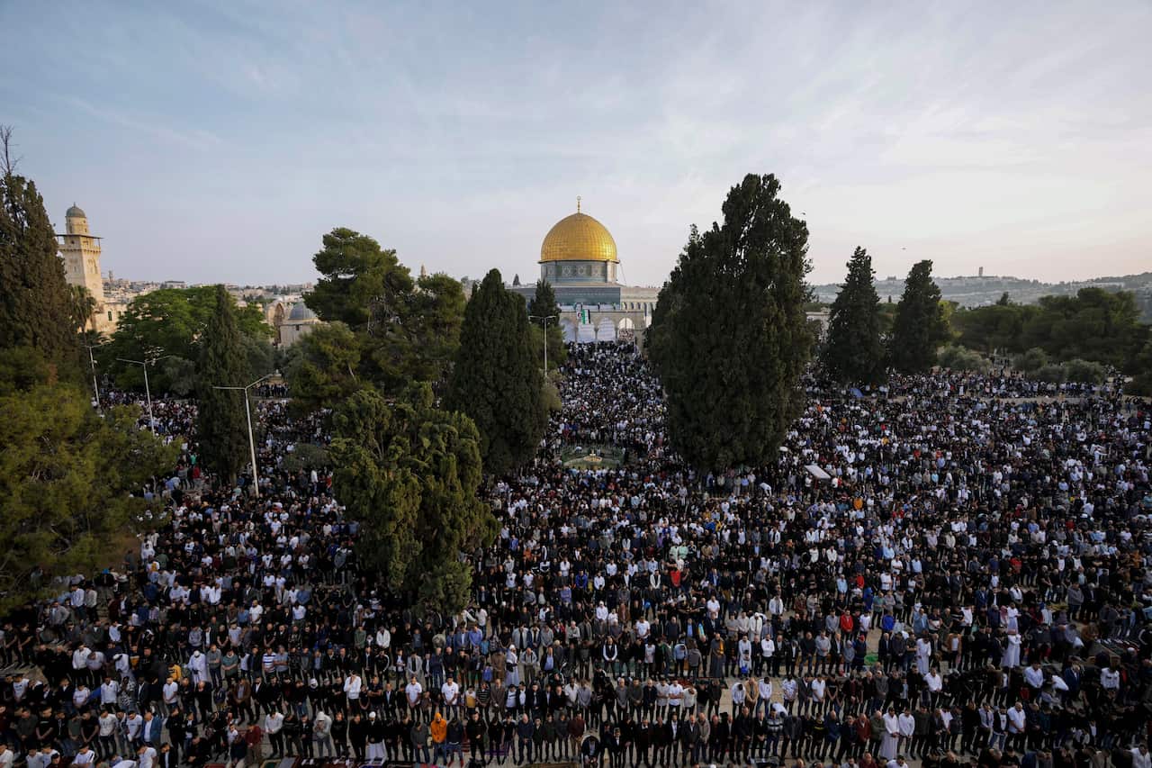 A wide shot showing thousans of people gathered outside a mosque