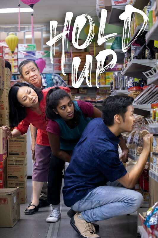 Characters from the film Hold Up hide behind shelves in an Asian grocery.