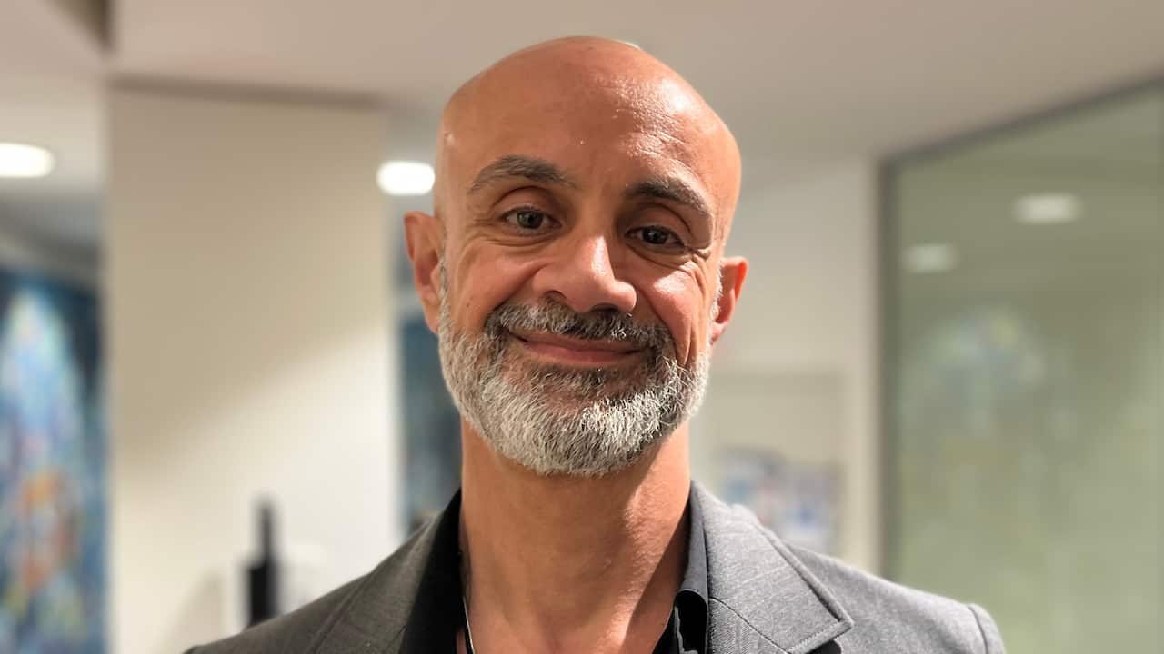 a closeup of a middle aged man with a bald head and grey beard