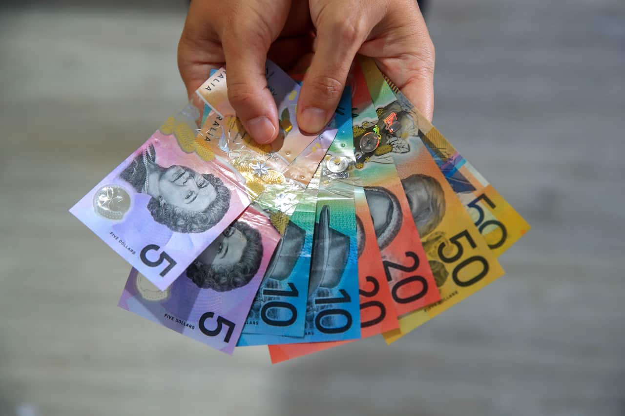 A person holds Australian banknotes 