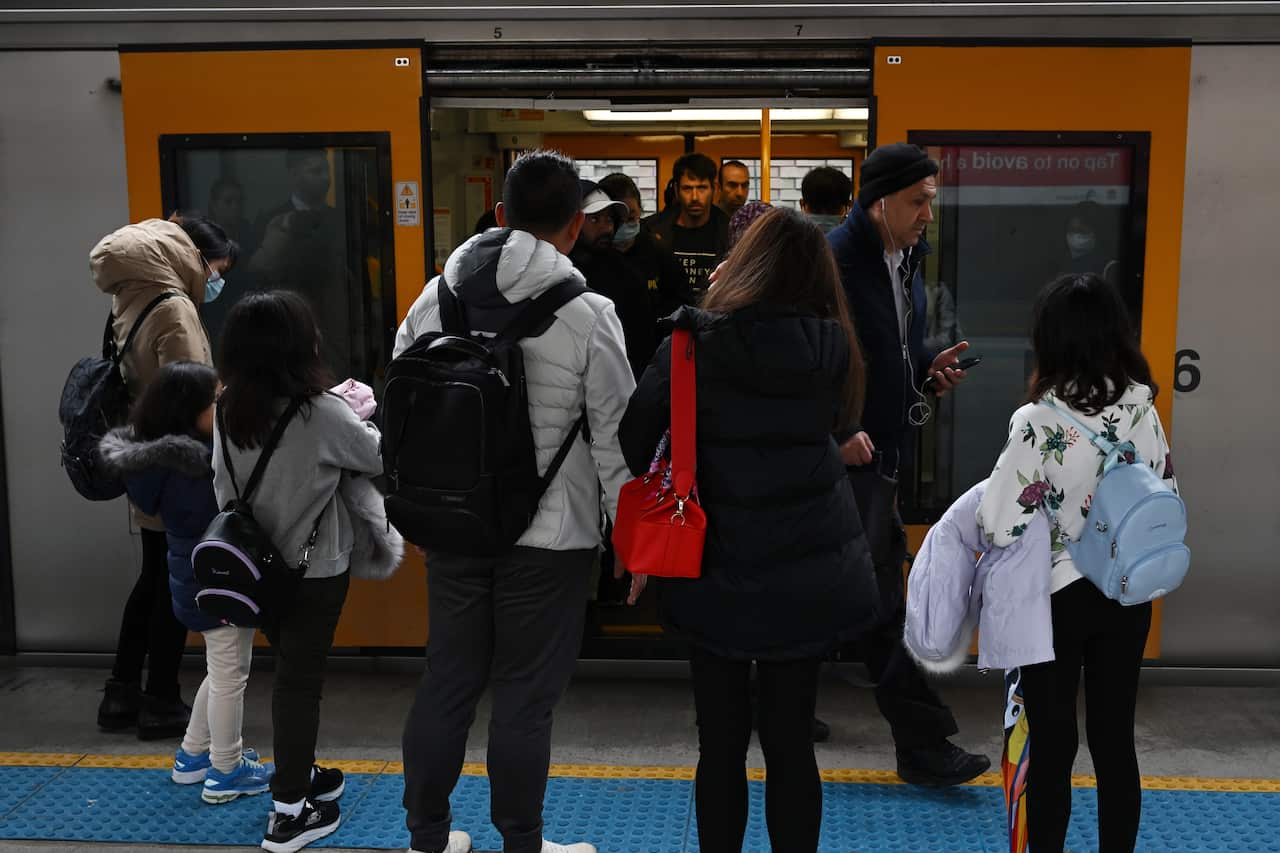 A group of people entering and exiting a train.