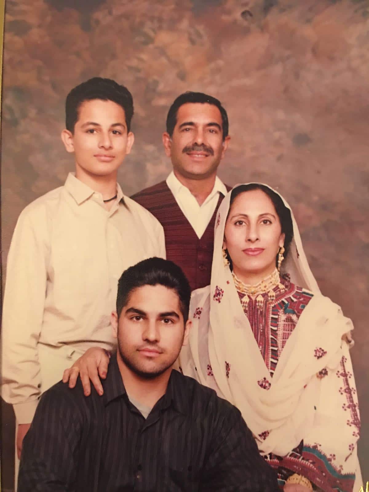 Taufiq Rind (sitting left) at the age of 15 with his younger brother and parents. 