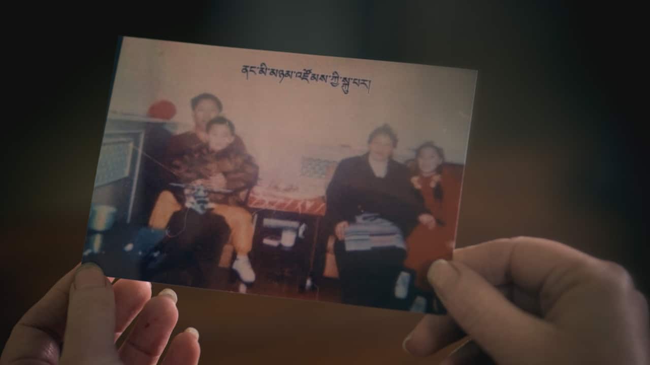 A photo, believed to be of the missing Panchen Lama and his family, shows a young boy sitting on a man's lap with two women also sitting near him.
