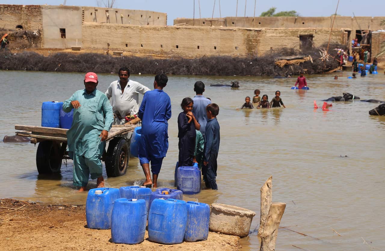People affected by floods move on higher grounds in Sehwan district, Sindh province, Pakistan, 31 August 2022.
