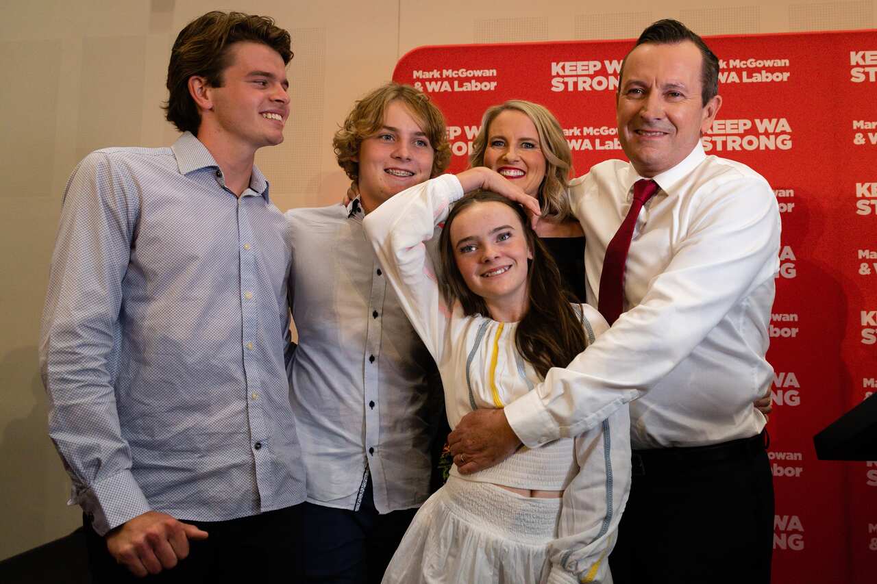 A man, his wife, and their children posing for a photo.