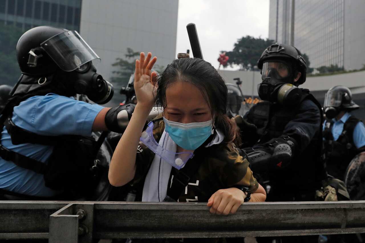 A protester reacts as she is tackled by riot police during a massive demonstration outside the Legislative Council in Hong Kong in 2019.