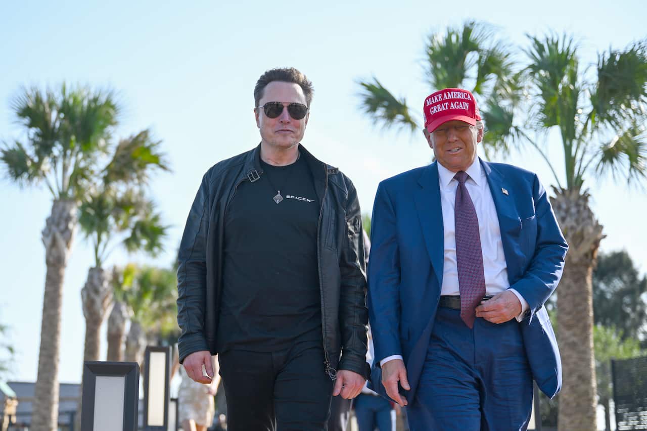 Elon Musk and Donald Trump walking down a street lined with palm trees.