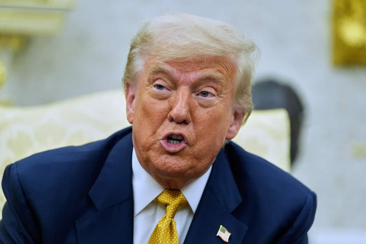 Donald Trump wearing a blue suit and yellow tie.