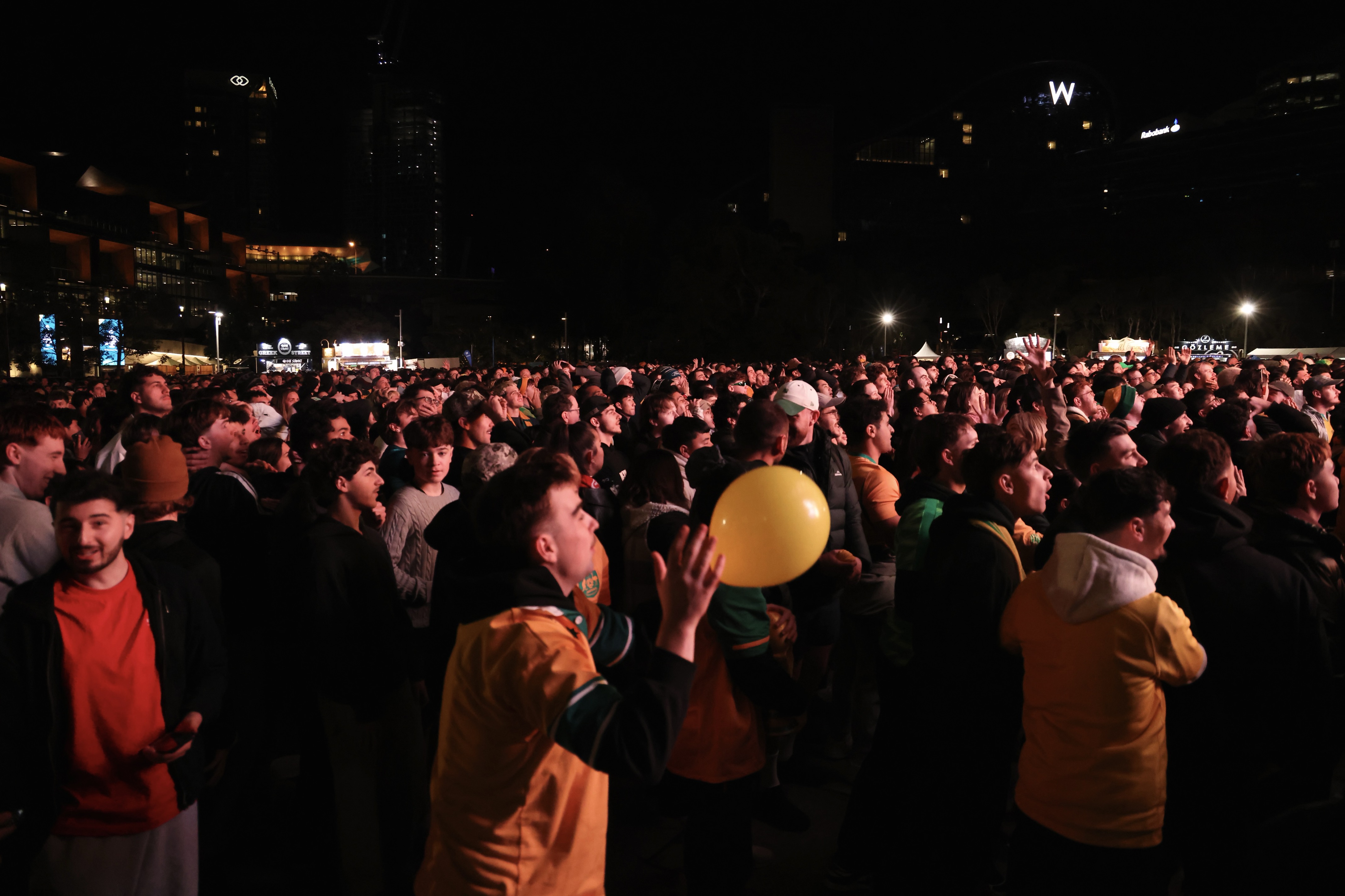 A large crowd of Socceroos fans standing in a park