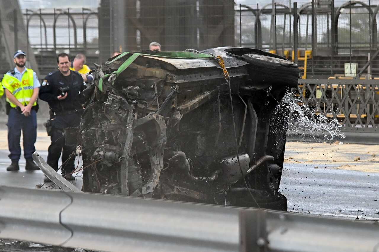 A badly damaged vehicle on its side on a roadway