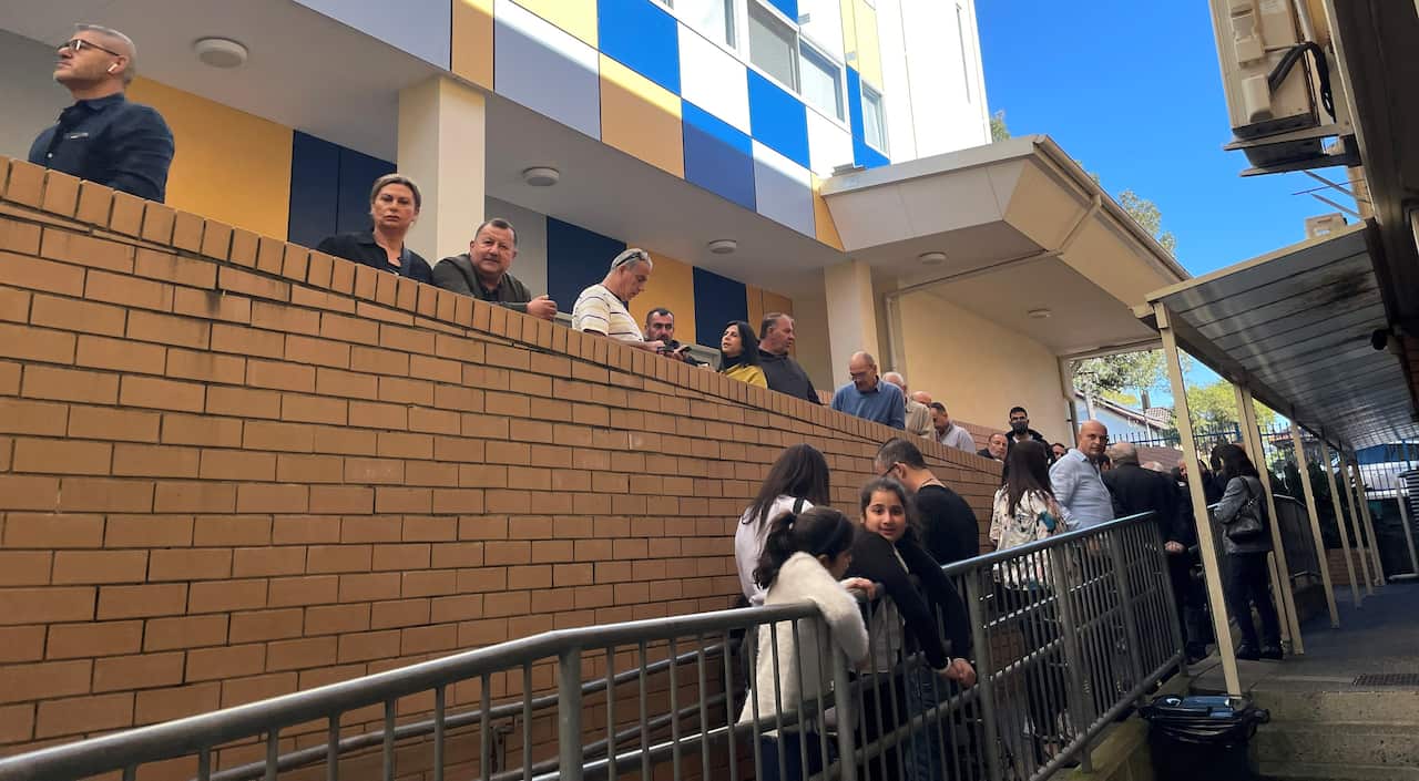 A queue of people outside a building.