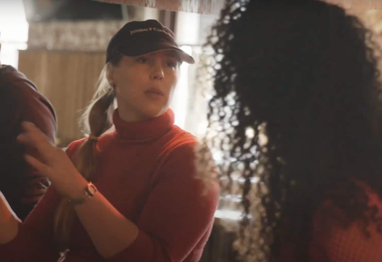 A woman wearing a red jumper and blue cap