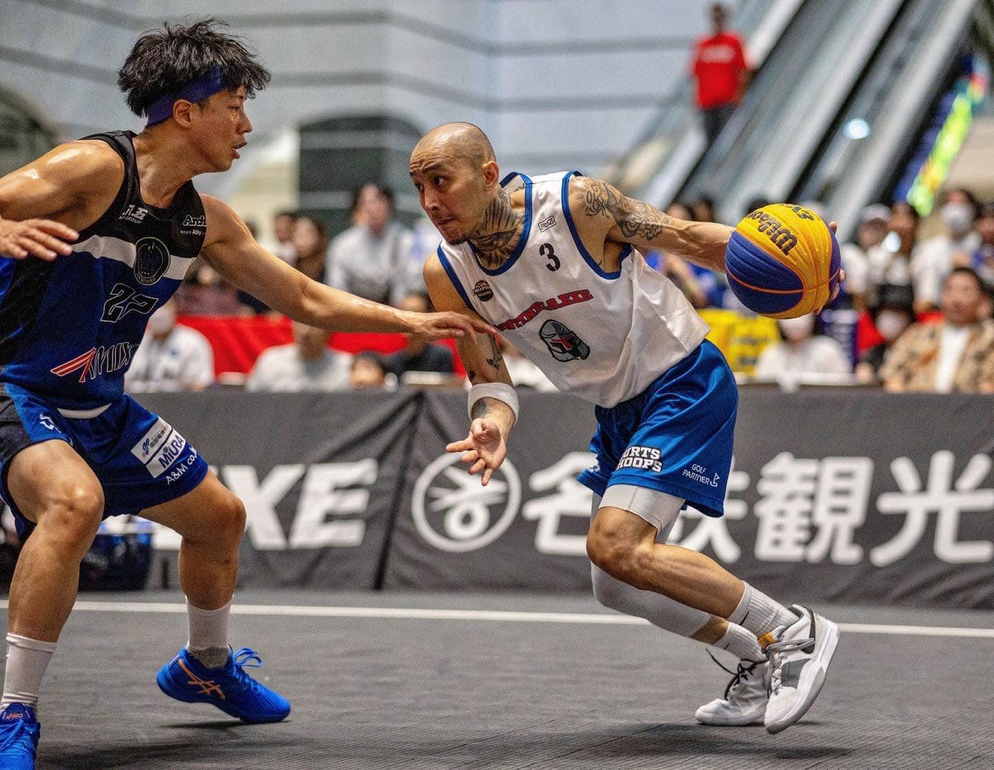 A man driving down the court with a basketball with another player guarding him.