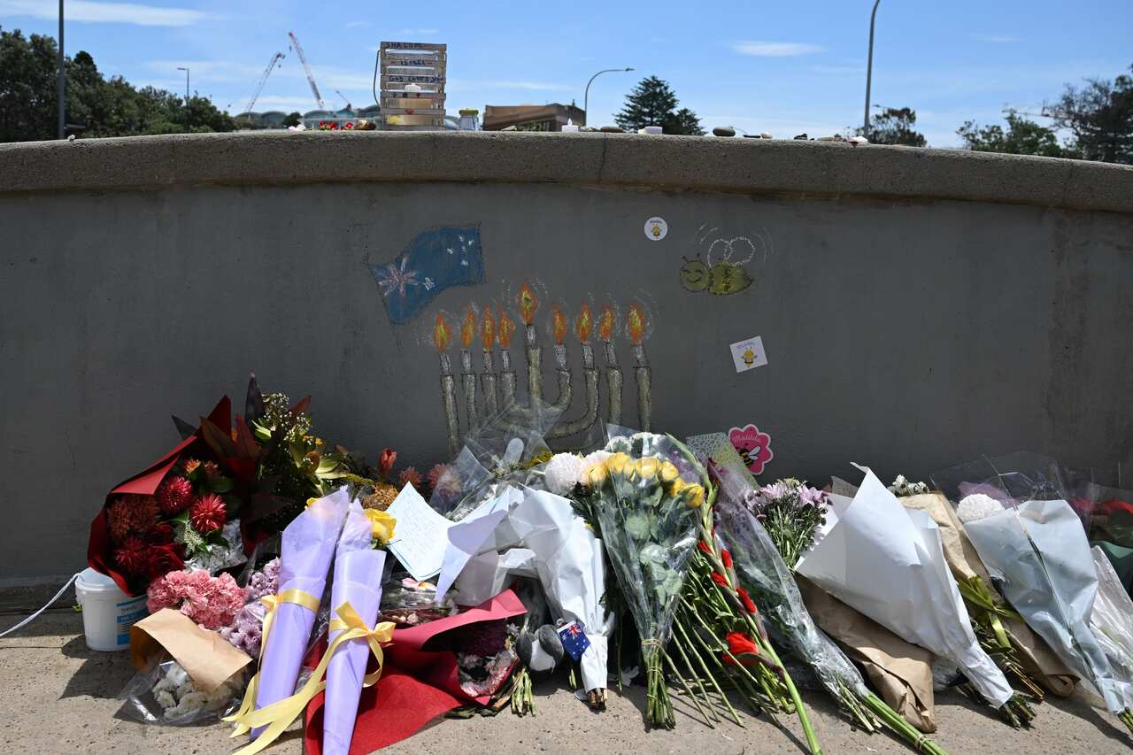 Flowers placed against a wall with a menorah painted on it.