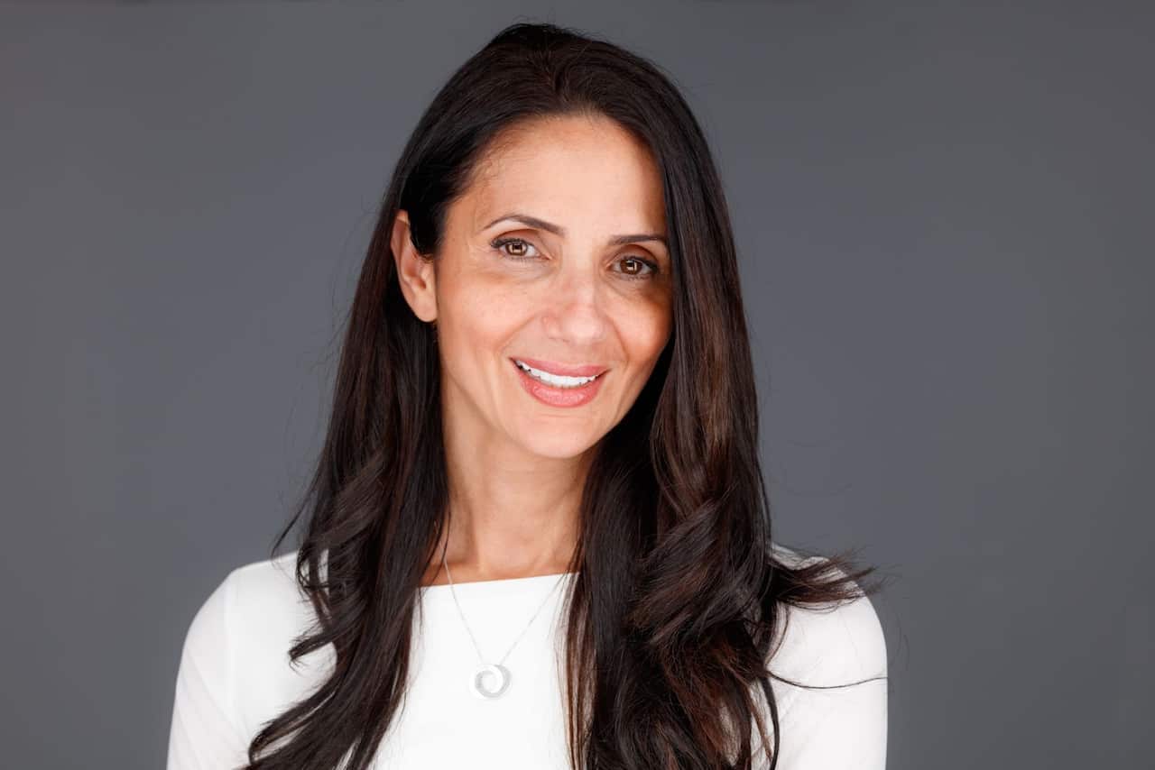 A woman in a white top smiling