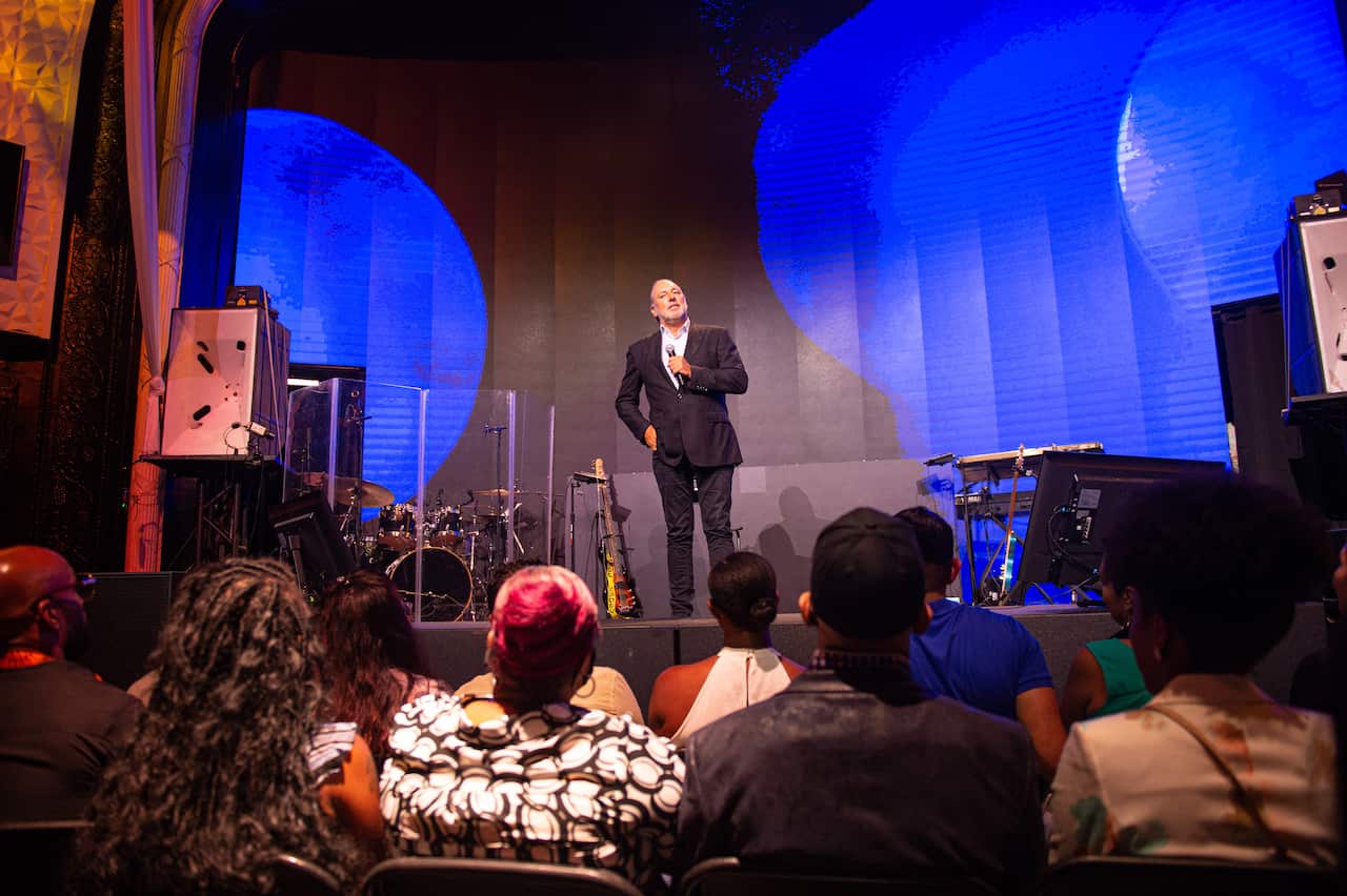 Brian Houston is seen speaking on stage.