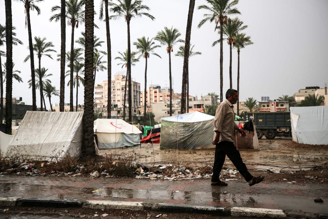 A man walks across a flooded street in Gaza.