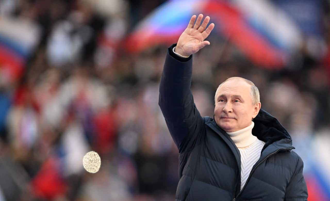Russian President Vladimir Putin waves during a concert marking the eighth anniversary of Russia's annexation of Crimea at the Luzhniki stadium in Moscow.
