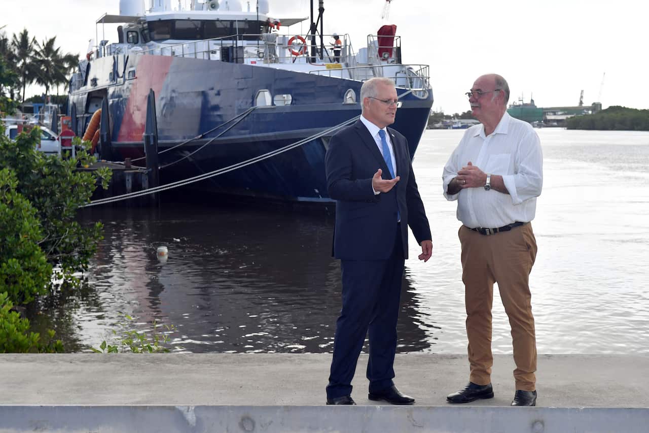Scott Morrison (left) and Warren Enstch stand in front of a boat in Cairns 