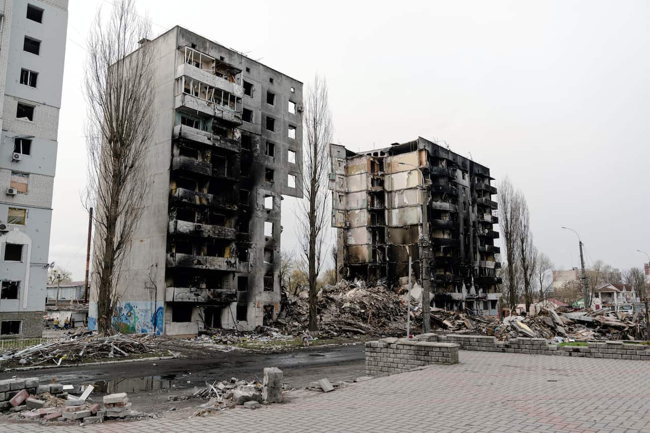 Destroyed residential buildings and mounts of debris are seen.