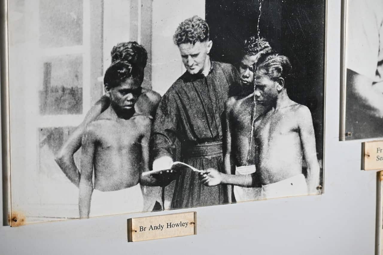 Bernard Tipiloura (second from the right) stands with three other students and Catholic Brother Andy Howley. Andy Howley wears clerical clothing and the Tiwi boys wear only shorts.