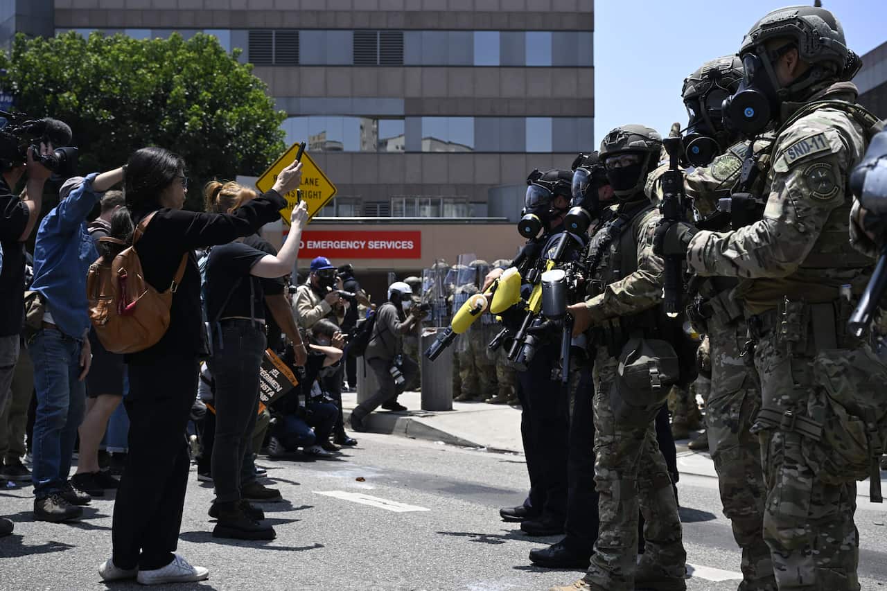 A group of protesters standing across from uniformed law enforcement.