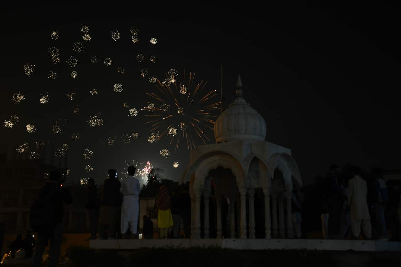 Fireworks in the sky, people watching on.