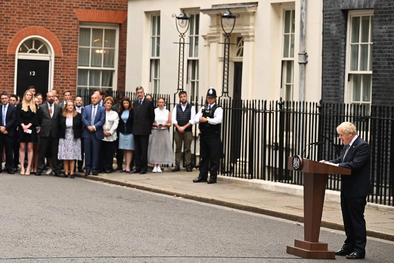Blurred background of people watching Boris Johnson stand at a podium