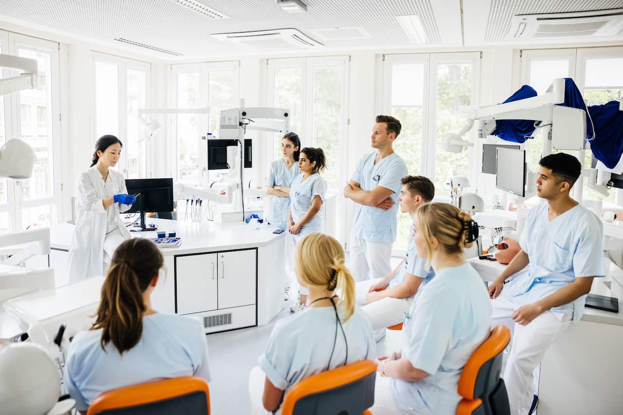 Students Listening To Teacher Talking In Dental Surgery