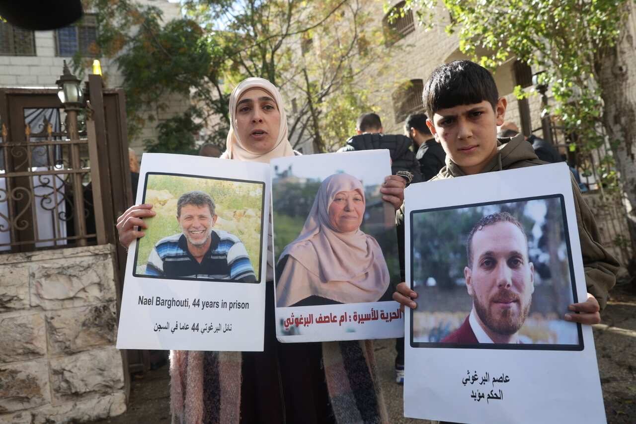 Palestinians, holding banners and photos of their relatives.
