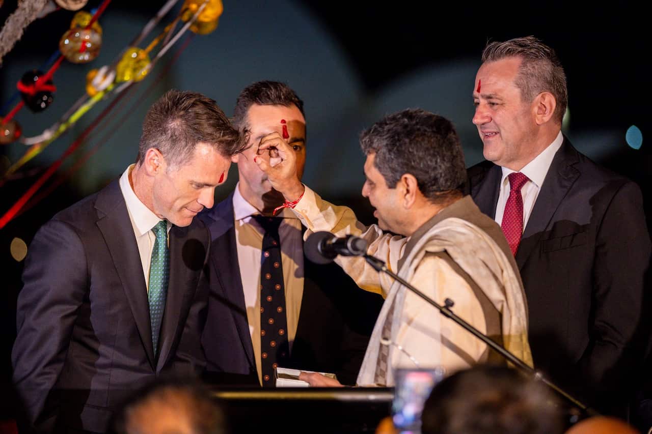 Hindu priest offering 'Tilak', an ornamental spot worn on the forehead, to (from left to right) Premier Chris Minns, Multicultural NSW CEO Joseph La Posta, and Minister for Multiculturalism Steve Kamper.