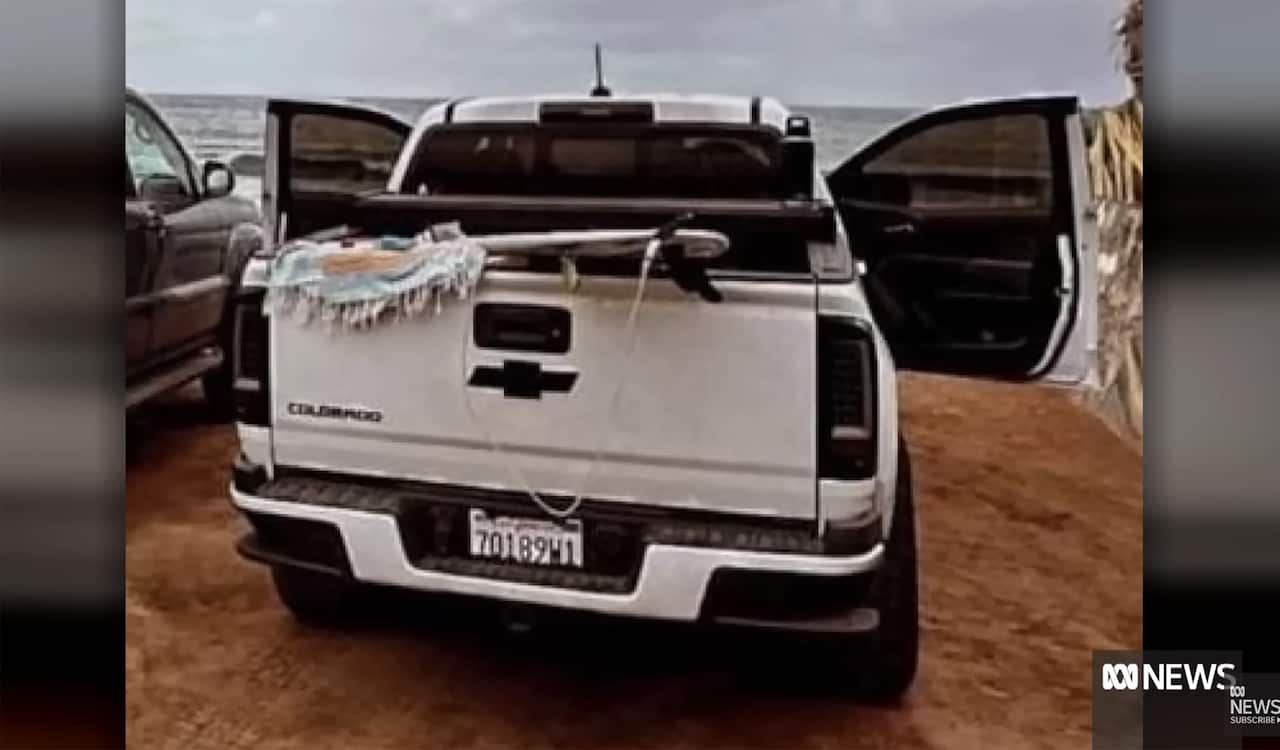 The back of a white Chevrolet ute, with both its doors wide open.