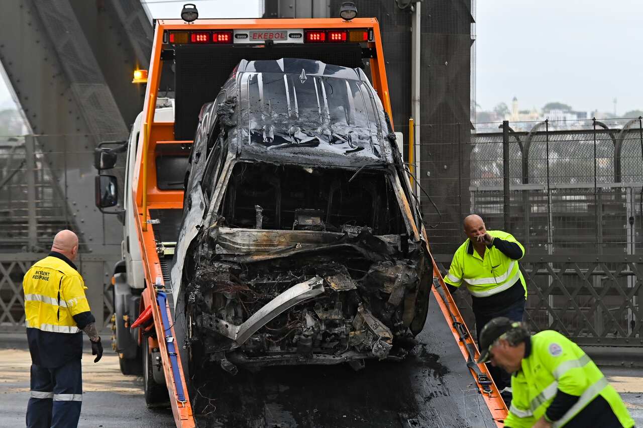 A car wreck is loaded onto a truck on the Sydney Harbour Bridge after a road accident.
