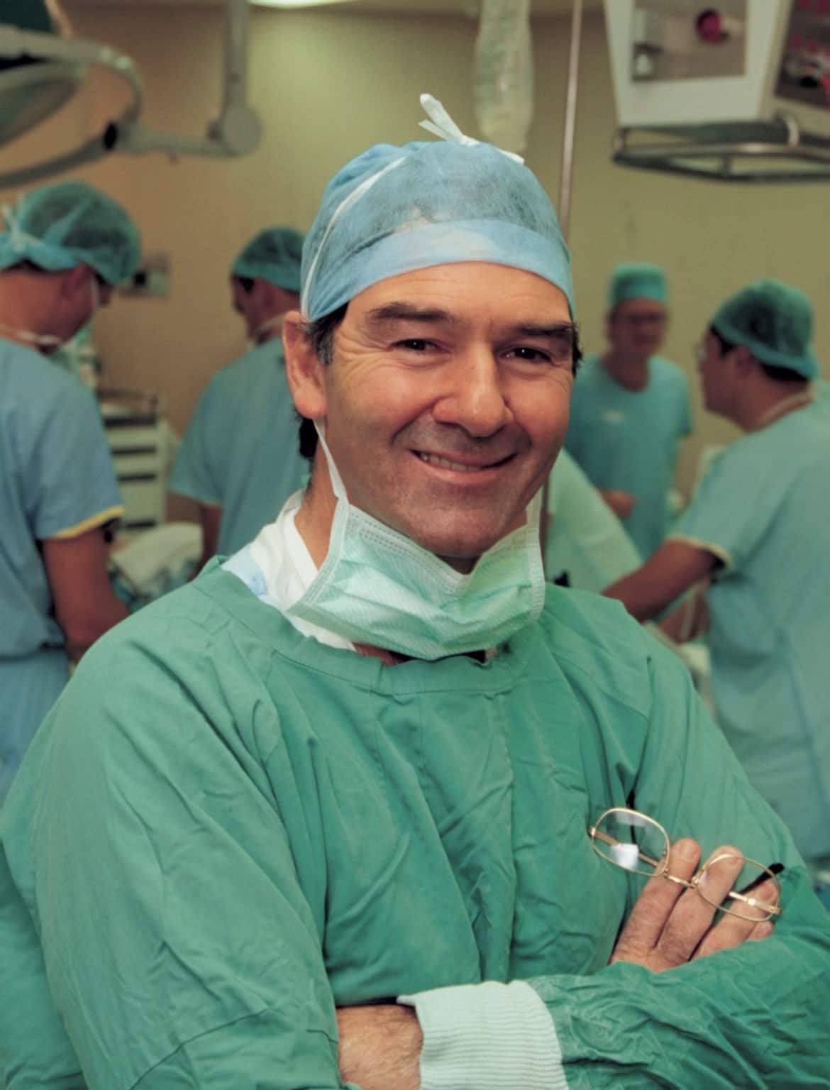 Dr Chris O'Brien in an operating theatre in green hospital scrubs.
