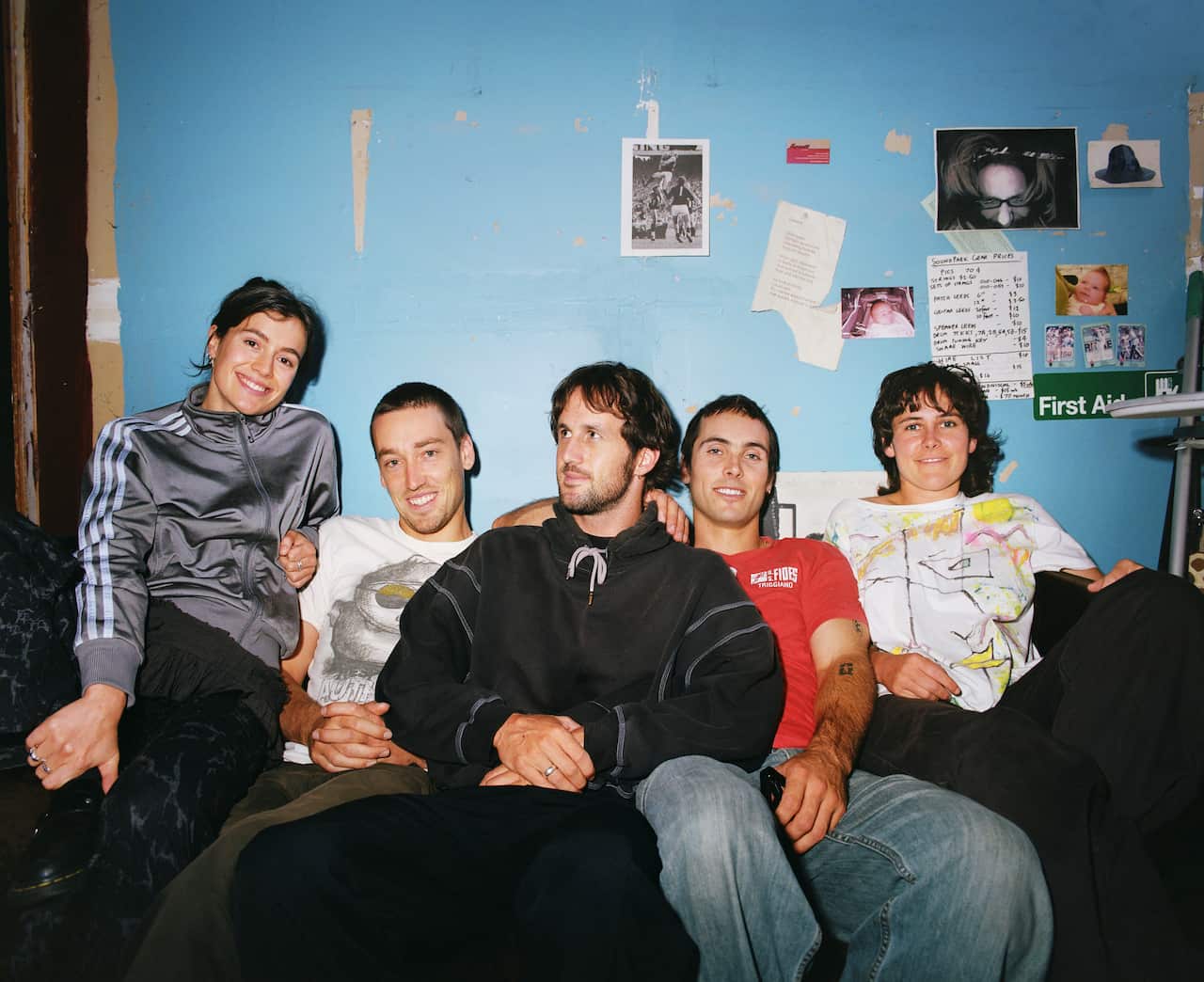 A group  of people sitting down and smiling at a camera. 