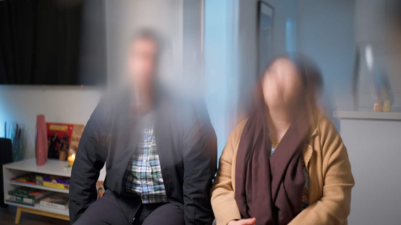 A couple seated. Faces are blurred.