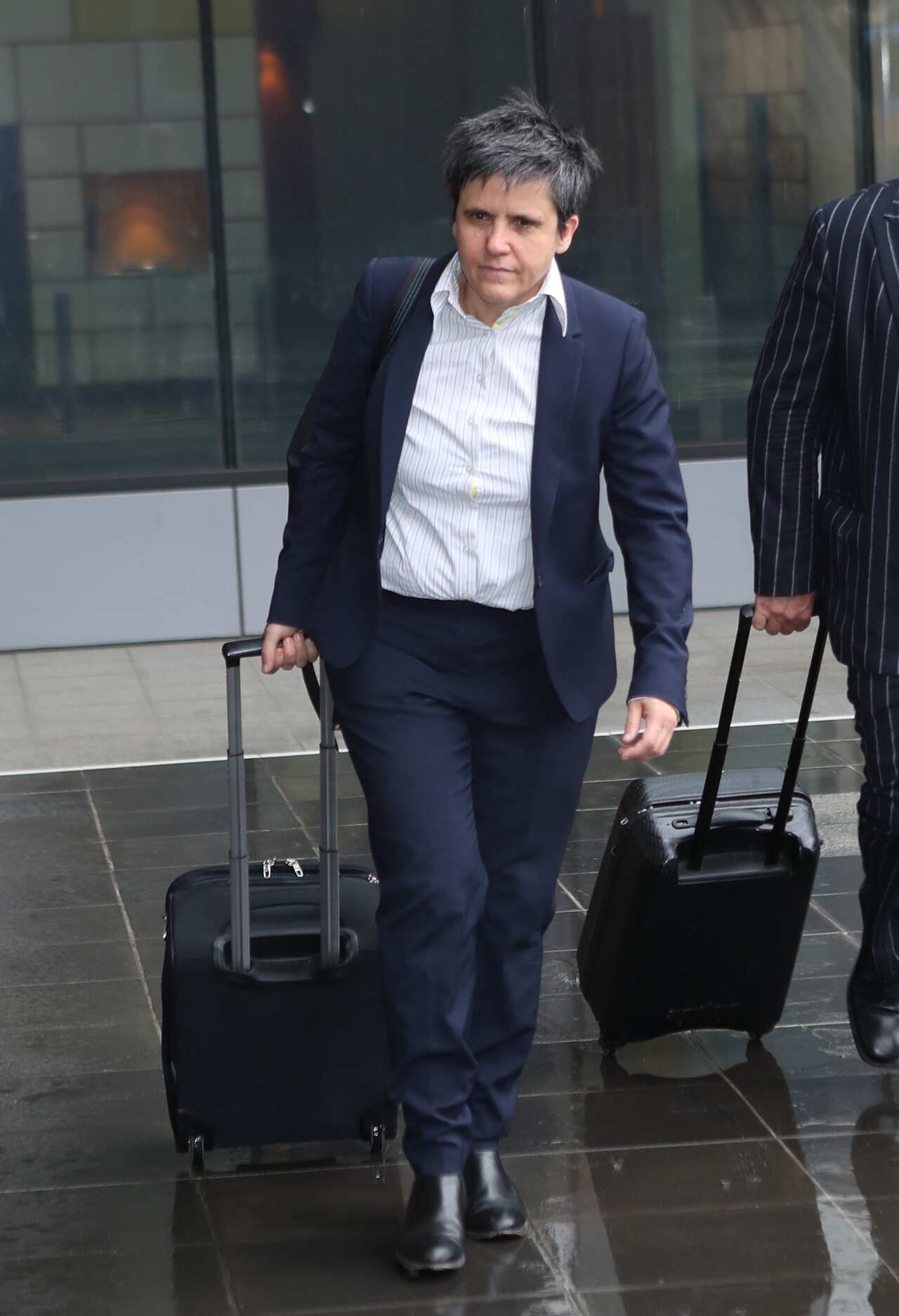 A woman wearing formal attire walking outside.