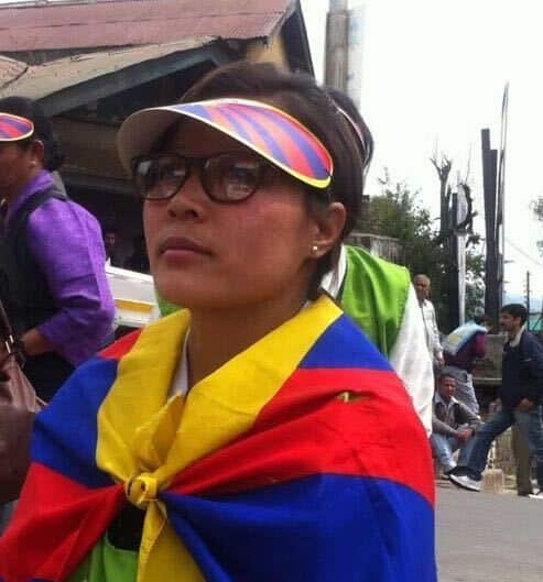 A woman draped in a colourful flag.