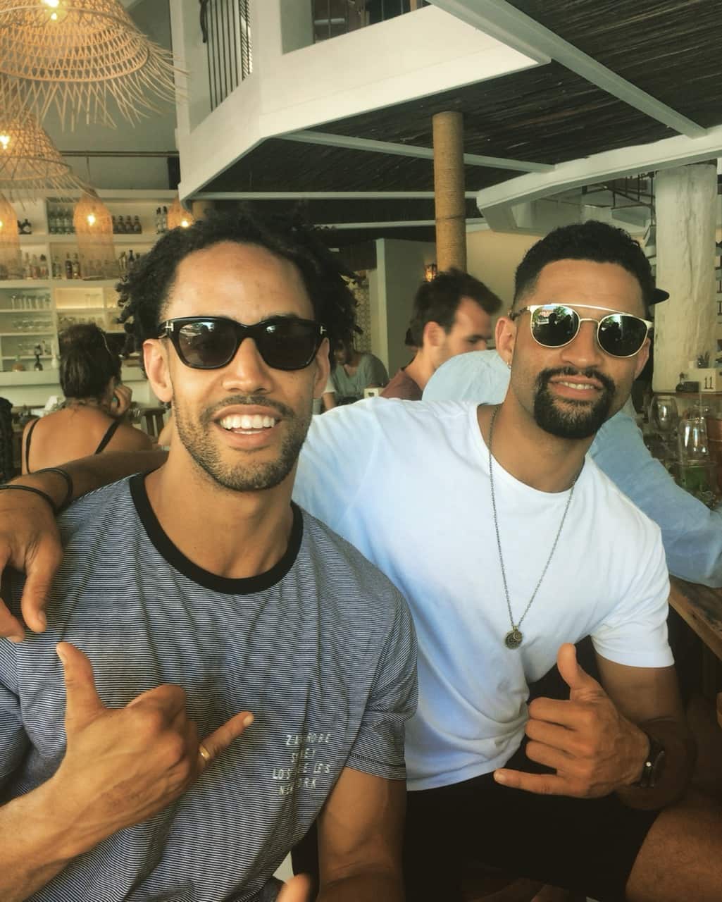 Two young men wearing sunglass pose